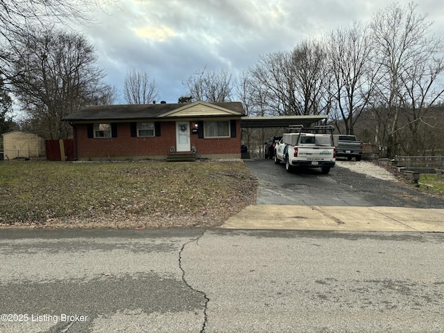 view of front of home featuring a carport, driveway, and brick siding