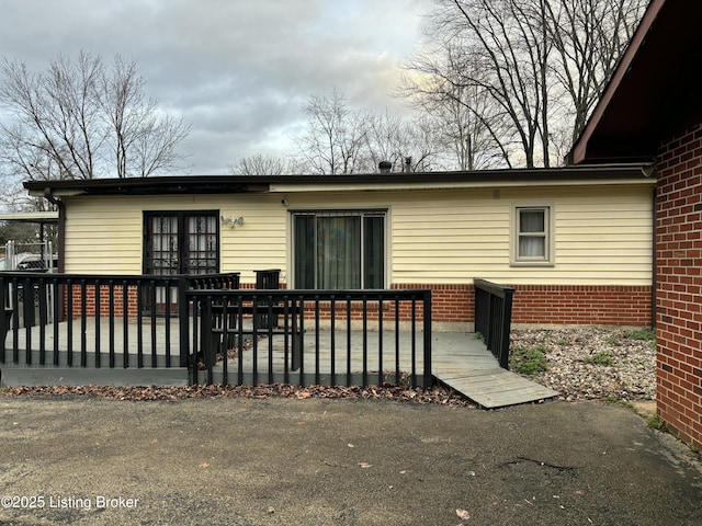 back of property with a deck and brick siding