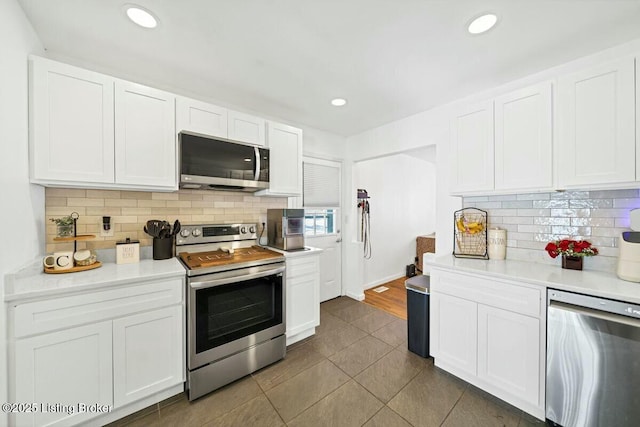 kitchen featuring stainless steel appliances, light countertops, white cabinetry, and recessed lighting