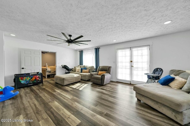 living area with recessed lighting, a textured ceiling, and wood finished floors