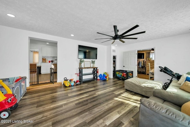 living area featuring a textured ceiling, wood finished floors, a ceiling fan, and recessed lighting