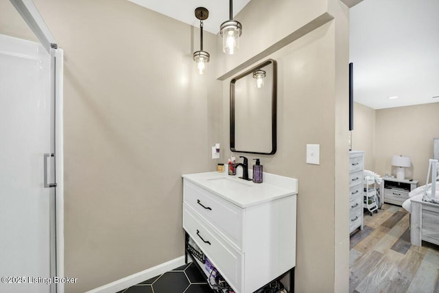 bathroom with vanity, baseboards, and wood finished floors