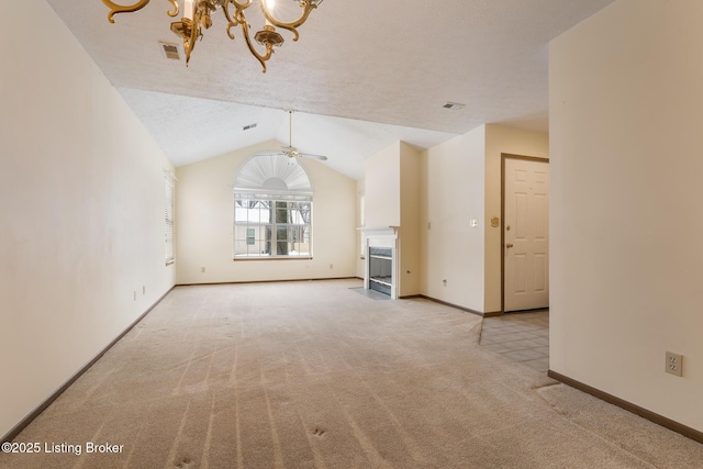 unfurnished living room with light carpet, ceiling fan with notable chandelier, lofted ceiling, and a textured ceiling