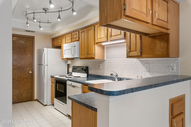 kitchen featuring sink, light tile patterned floors, white appliances, and decorative backsplash