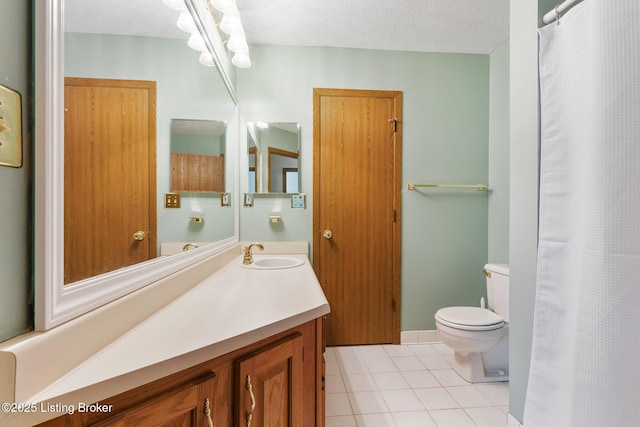 bathroom with tile patterned flooring, vanity, toilet, and a textured ceiling