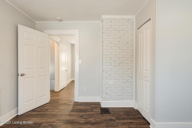 interior space featuring crown molding, dark hardwood / wood-style flooring, and a textured ceiling