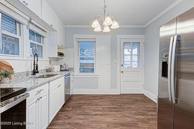 kitchen featuring dark wood-type flooring, sink, pendant lighting, stainless steel appliances, and white cabinets