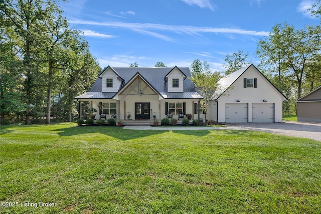 modern farmhouse with covered porch, metal roof, a front lawn, and a garage