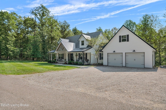 view of front of home with a porch, a front yard, metal roof, and driveway