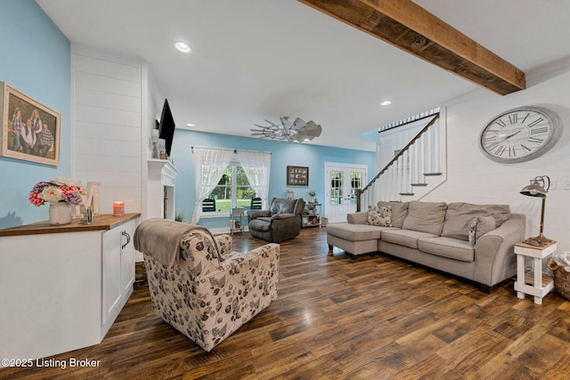 living area featuring dark wood-style flooring, beamed ceiling, french doors, and stairs