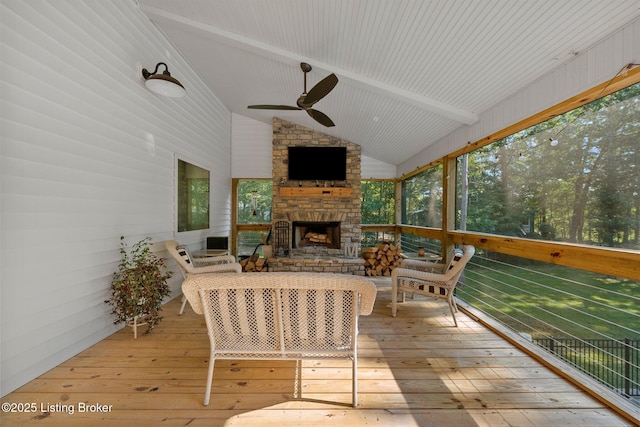 sunroom with lofted ceiling with beams, ceiling fan, and a fireplace