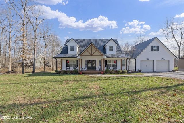 view of front of house featuring a garage, driveway, metal roof, a porch, and a front yard