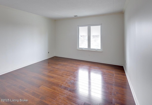 unfurnished room with dark wood-type flooring and ornamental molding