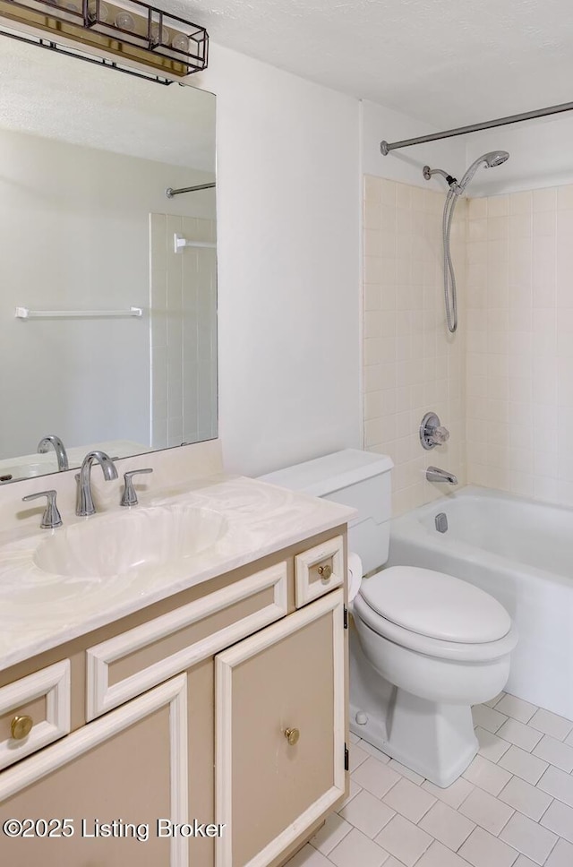 full bathroom featuring tiled shower / bath, vanity, and toilet