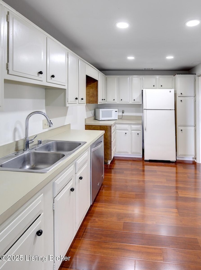 kitchen featuring dark hardwood / wood-style floors, white cabinetry, sink, and white appliances