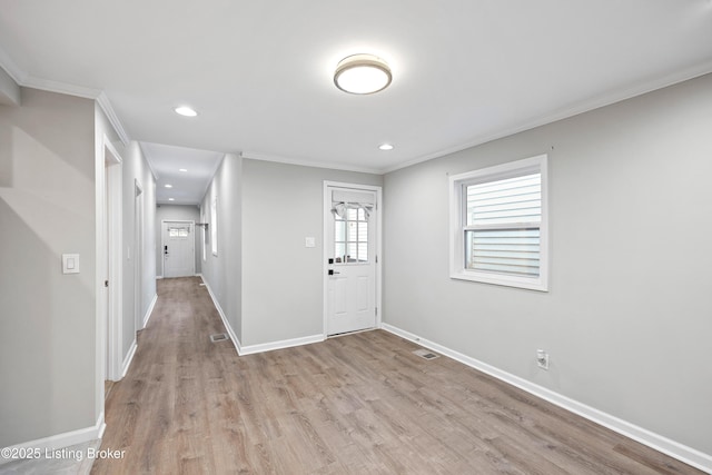 entryway featuring ornamental molding and light hardwood / wood-style floors