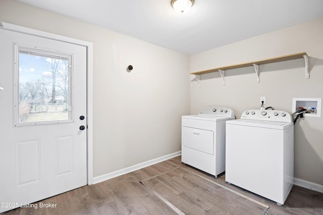 laundry area featuring washing machine and dryer and light hardwood / wood-style floors