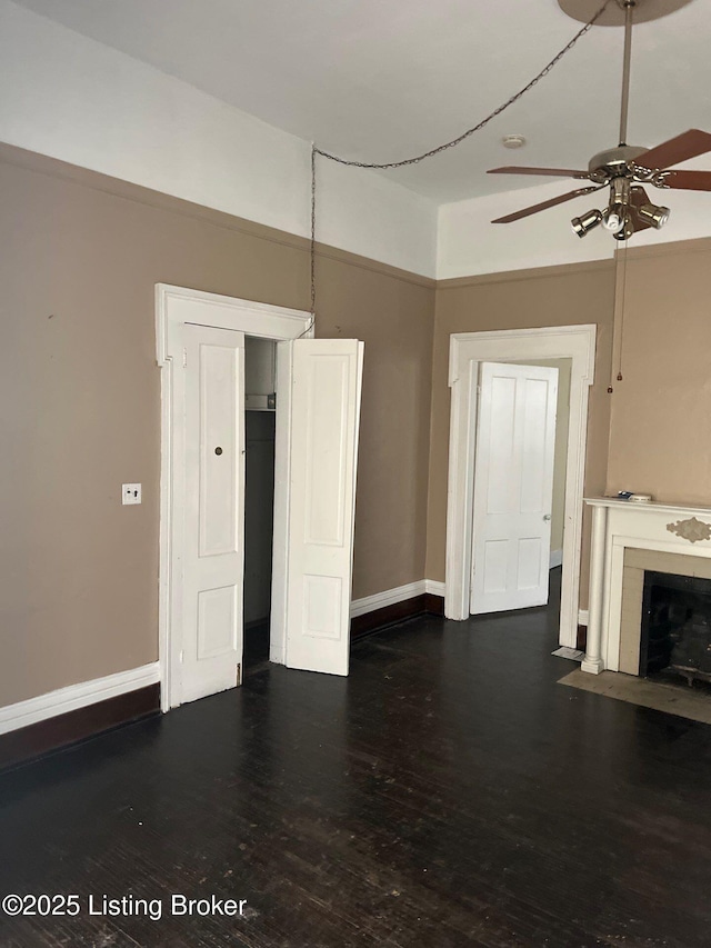 unfurnished living room with ceiling fan and dark hardwood / wood-style flooring