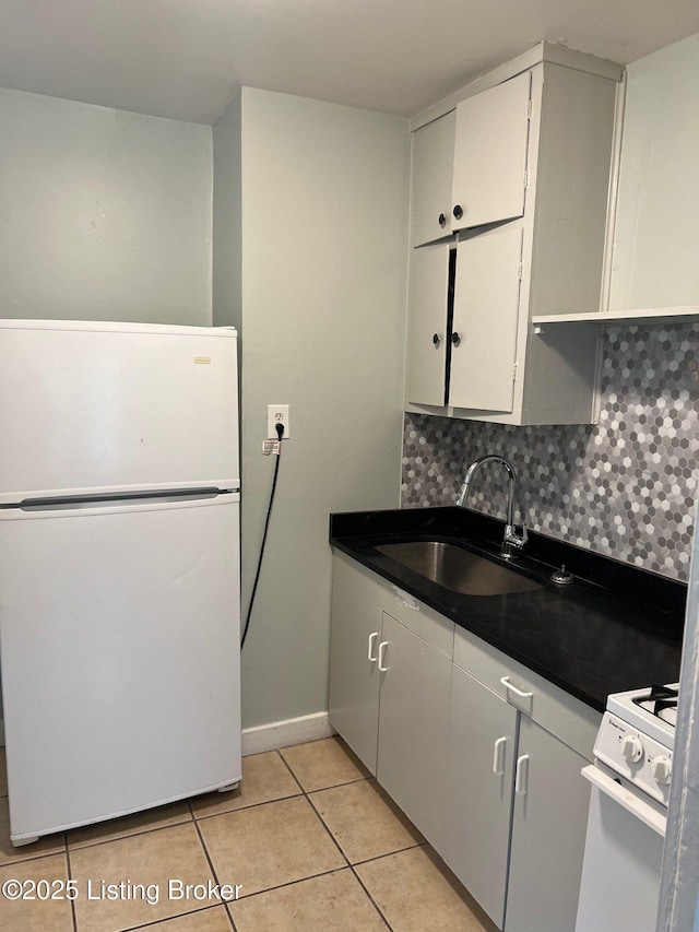 kitchen with sink, white cabinets, decorative backsplash, light tile patterned floors, and white appliances