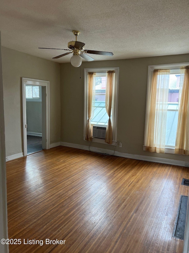 spare room with hardwood / wood-style flooring, a textured ceiling, and a healthy amount of sunlight