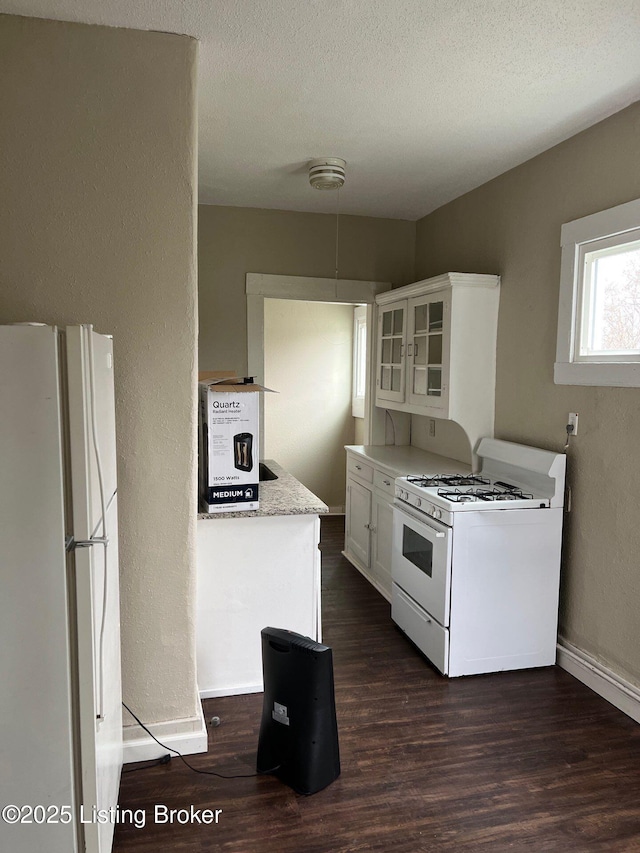 kitchen with white cabinetry, white appliances, dark wood-type flooring, and a textured ceiling