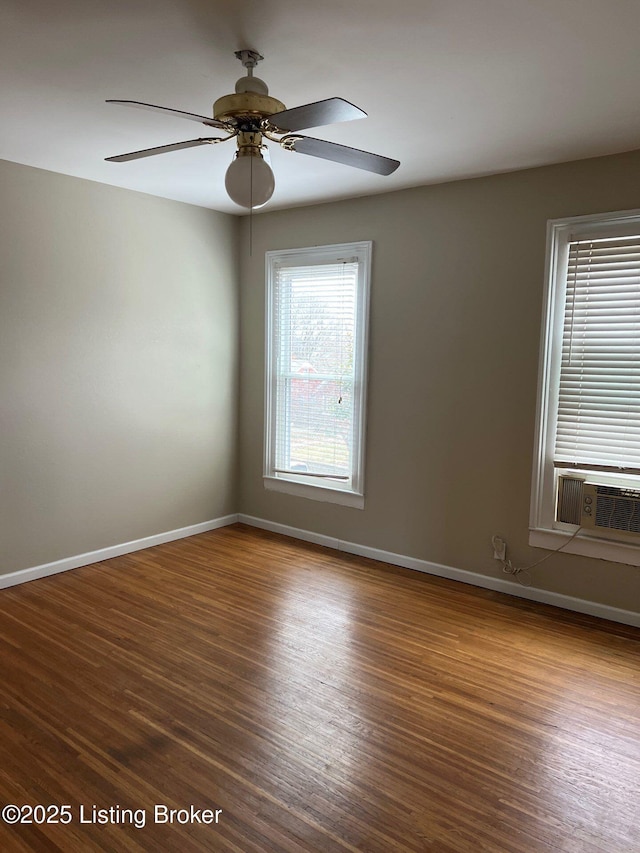 empty room featuring wood-type flooring, cooling unit, and ceiling fan