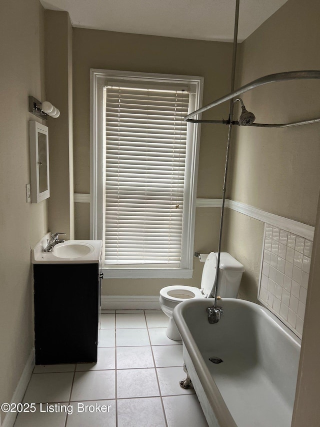 bathroom with vanity, toilet, tile patterned flooring, and a tub