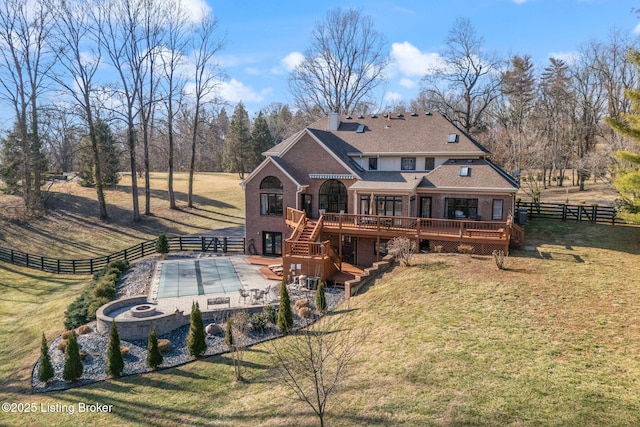 back of house featuring a lawn, a patio, stairway, a deck, and brick siding