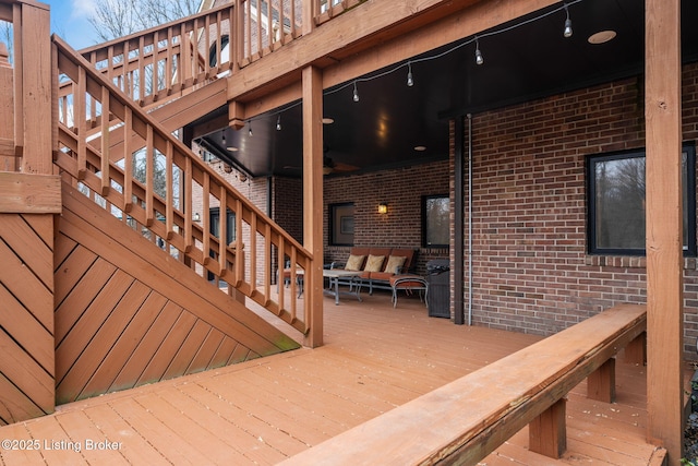 wooden terrace featuring an outdoor living space and stairs