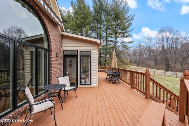 wooden terrace featuring outdoor dining area and fence