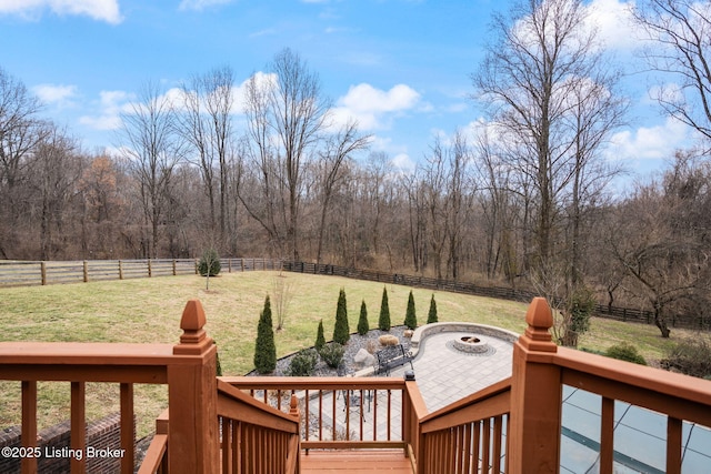 view of yard with an outdoor fire pit, a rural view, fence, and a wooden deck