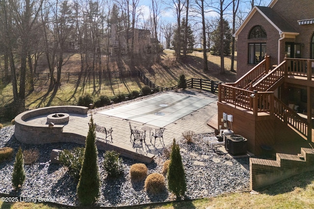 view of patio featuring stairs, an outdoor fire pit, fence, and central air condition unit