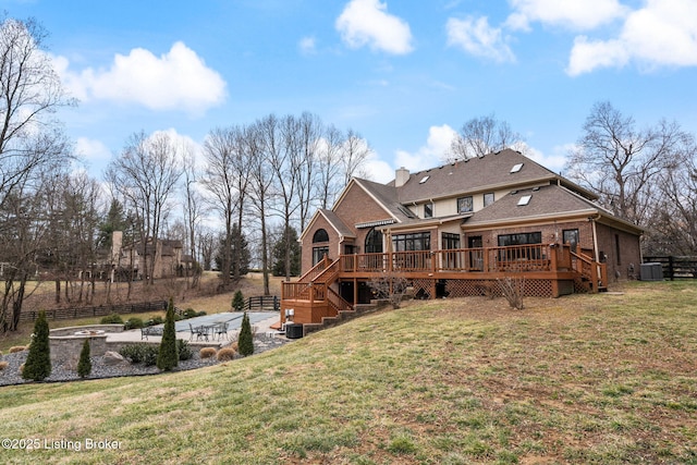 back of house with a lawn, a patio, stairs, a deck, and brick siding