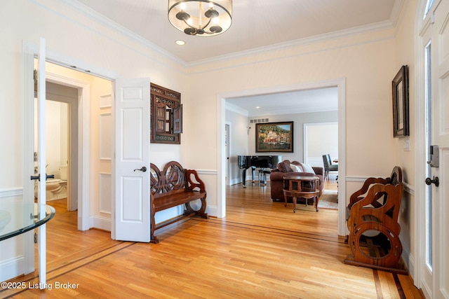 hall featuring recessed lighting, baseboards, light wood-style floors, an inviting chandelier, and crown molding