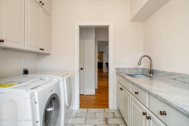 washroom featuring washer and clothes dryer, a sink, and cabinet space