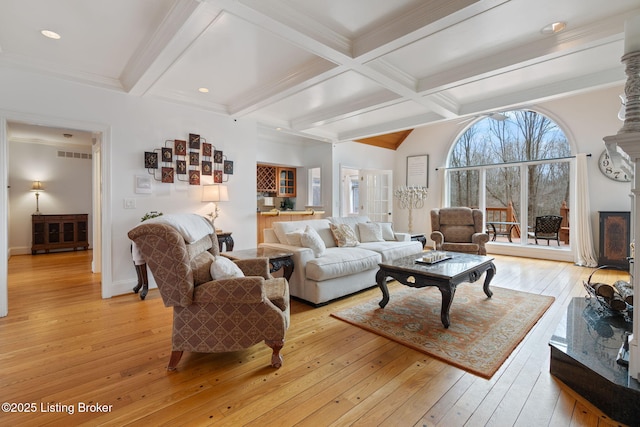 living room with light wood finished floors, beamed ceiling, coffered ceiling, and visible vents