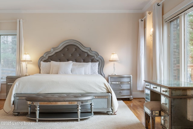 bedroom with ornamental molding and light wood-type flooring