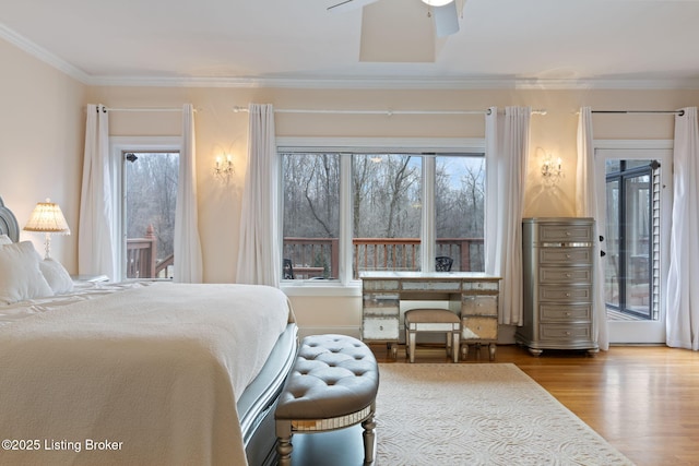 bedroom with ornamental molding, access to exterior, and wood finished floors