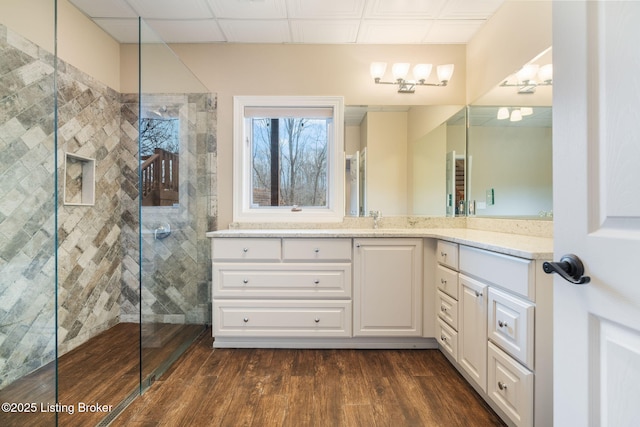 full bathroom featuring a walk in shower, vanity, and wood finished floors