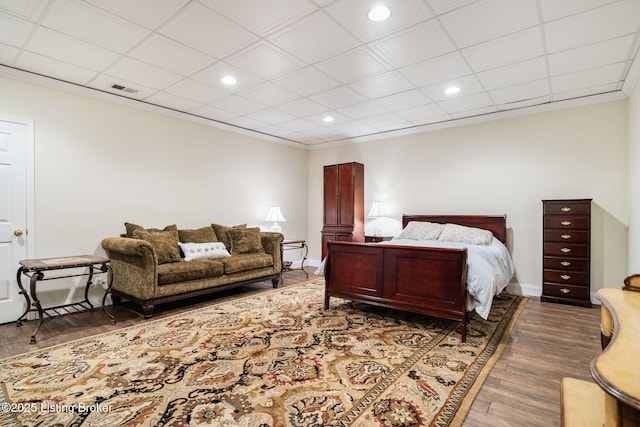 bedroom featuring baseboards, visible vents, dark wood-style floors, ornamental molding, and recessed lighting