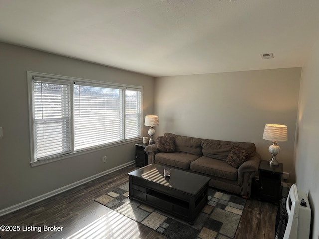 living area featuring dark wood-style floors, visible vents, and baseboards