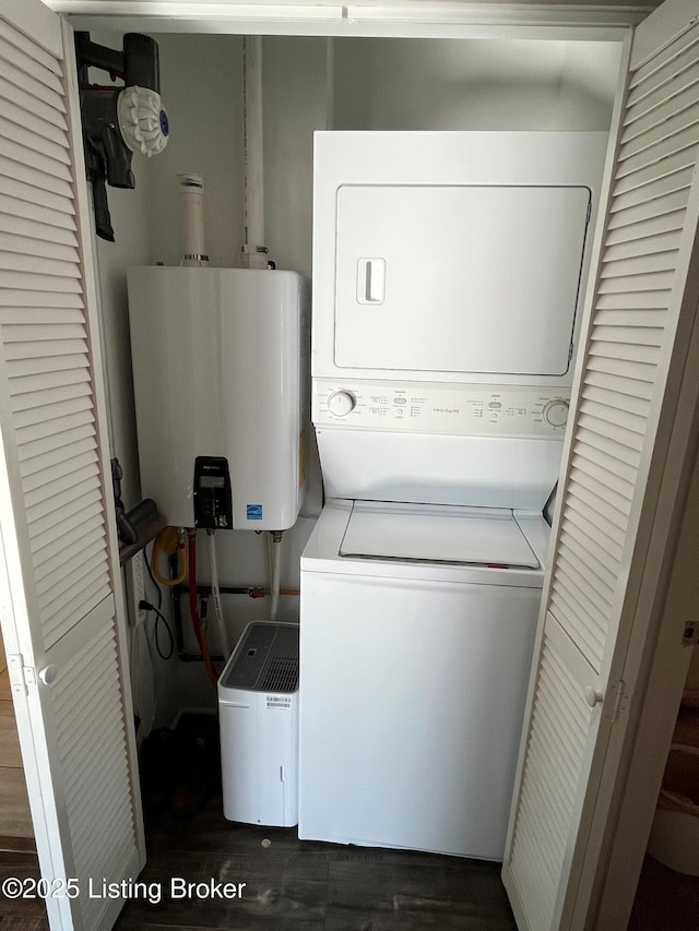 clothes washing area with water heater and stacked washing maching and dryer