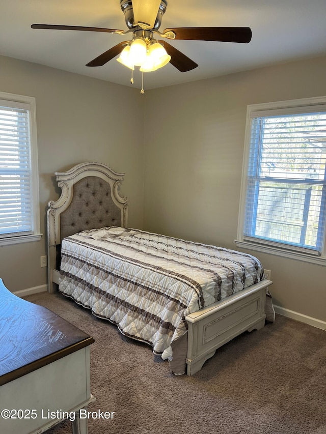 carpeted bedroom with ceiling fan, multiple windows, and baseboards