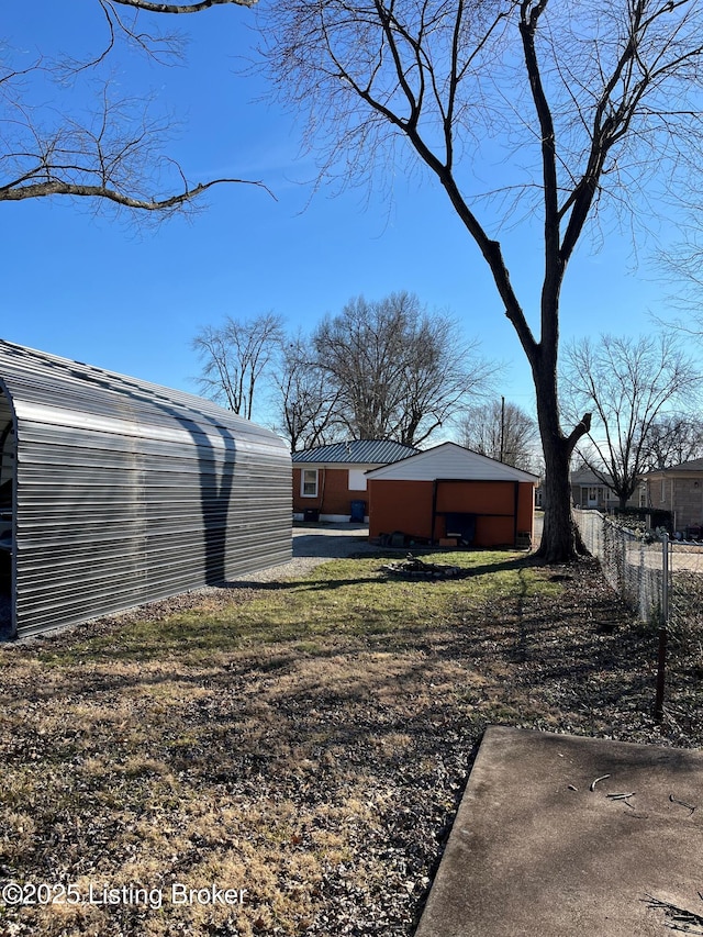 view of yard featuring fence and an outbuilding