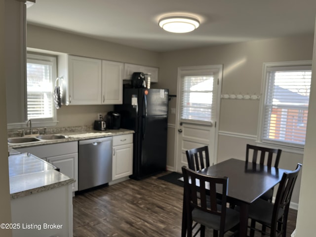 kitchen with plenty of natural light, white cabinets, dishwasher, freestanding refrigerator, and a sink