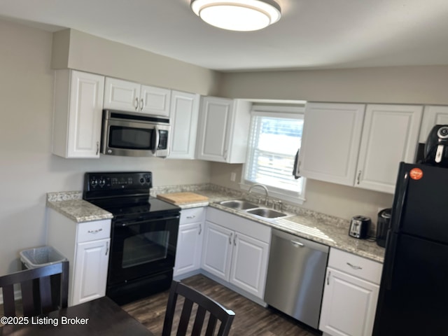 kitchen featuring a sink, white cabinetry, light stone countertops, black appliances, and dark wood finished floors