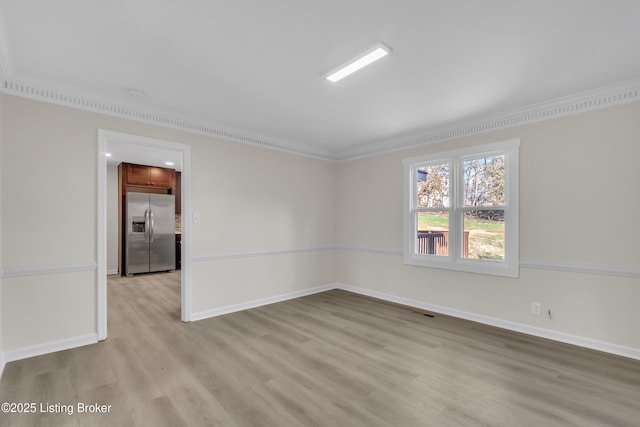 spare room with crown molding and light hardwood / wood-style flooring