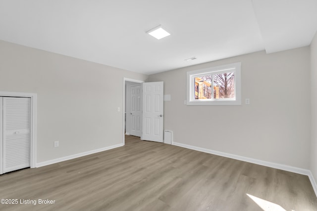 unfurnished bedroom with light hardwood / wood-style flooring and a closet