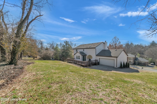 view of side of property featuring a wooden deck, a garage, and a lawn