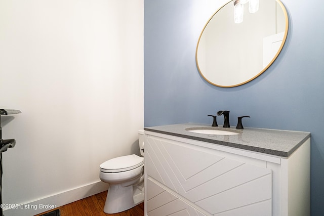 bathroom featuring vanity, hardwood / wood-style floors, and toilet